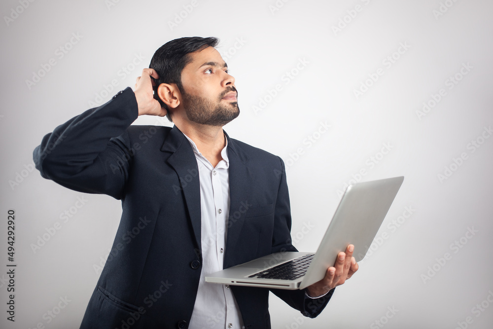 confused businessman thinking and using laptop isolated in white background confused businessman thinking and using laptop isolated in white background