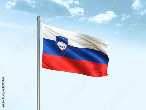 Slovenia national flag waving in blue sky with clouds. Slovenia flag. 3D illustration
