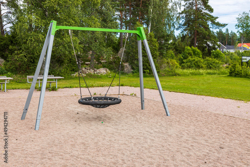 Beautiful view of children's swing on an empty playground on summer day. Sweden.