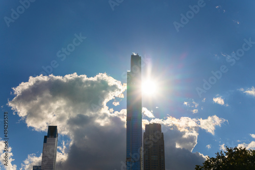The sun shines among clouds over the Ultra-luxury high-rise residential skyscraper in Billionaires's Row beyond the Sheep Meadow at Central Park in autumn on November 03, 2021 at New York City NY USA.