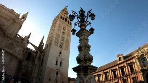 DOLLY SHOT - Farola Fountain and the Catedral de Sevilla (Cathedral of Saint Mary of the See) and La Giralda. Giralda is the name given to the bell tower of the Cathedral.