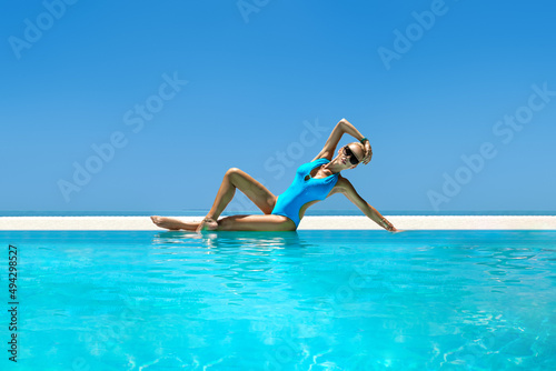Sexy woman in bikini in the pool at Maldives tropical island. Glamor model in elegant swimsuit in the pool. Perfect body bikini model. Exotic tour. Luxury travel. Travel, tourism. Bikini fashion.