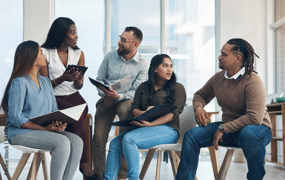 Our typical brainstorming session. Cropped shot of a diverse group of businesspeople sitting together and having a discussion in the office. Our typical brainstorming session. Cropped shot of a diverse group of businesspeople sitting together and having a discussion in the office.