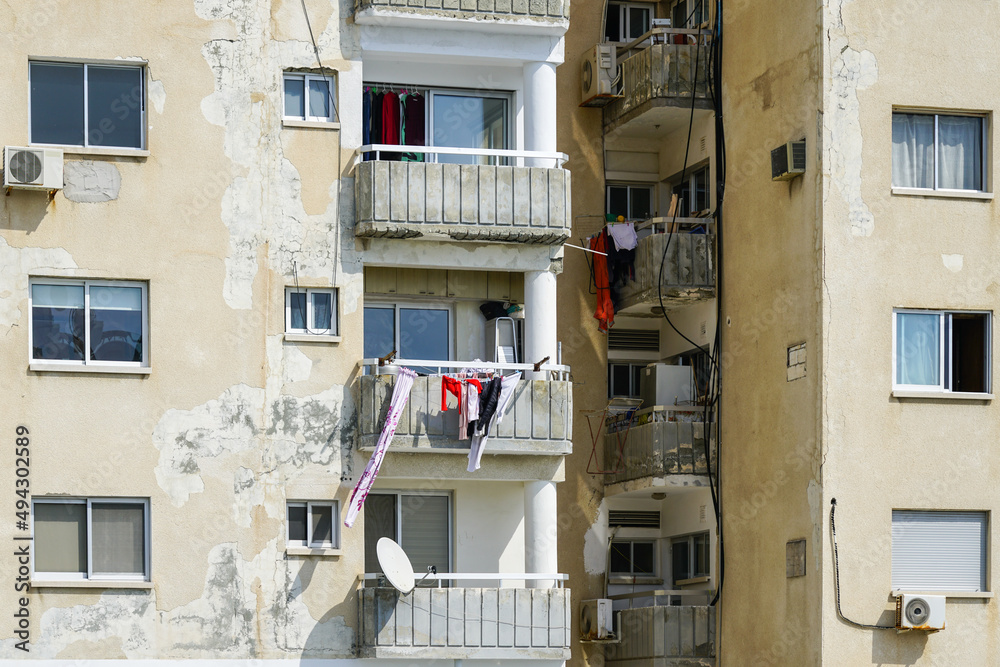 facade of a dilapidated apartment house with fallen plaster pieces ...