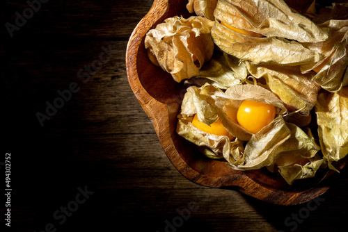 Physalis fruits on a wooden table. Sweet yellow physalis berries on wood background
