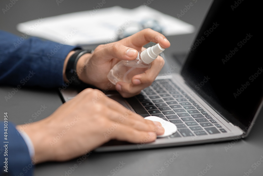 Unrecognizable man in suit cleaning laptop keyboard Unrecognizable man in suit cleaning laptop keyboard