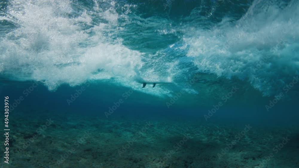 Underwater view of the surfer riding the wave Underwater view of the surfer riding the wave