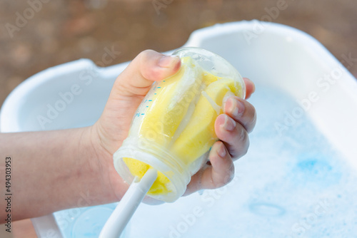 Washing baby bottle. Mother's hand washing the baby bottle