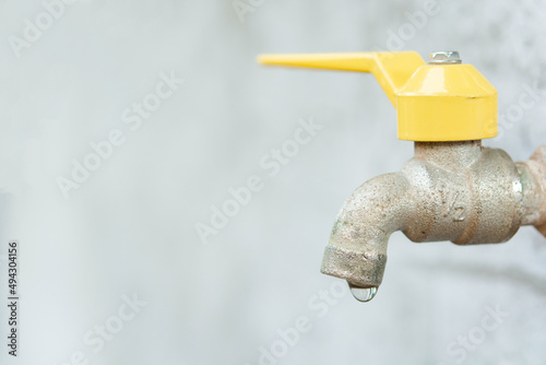 Faucet with a water drop. Old yellow faucet photo