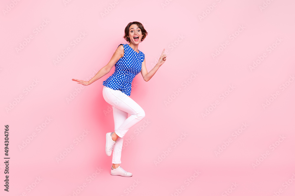 Full length photo of optimistic young brunette lady index promo wear blouse pants sneakers isolated on pink background