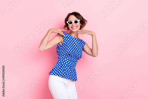 Photo of cute young brunette lady dance wear eyewear blue top jeans isolated on pink color background
