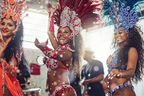 Come and have a festive time with us. Shot of samba dancers performing in a carnival. photo