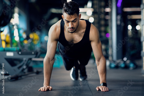Handsome Middle Eastern Man Making Push Up Exercises On Floor At Gym