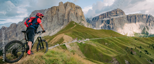 Mężczyzna podziwia widoki w górach Dolomitach . Rower górski z napędem elektrycznym w górach środkiem transportu