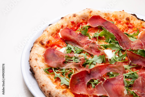 delicious italian pizza with tomatoes, ham, salami, cheese on a white background