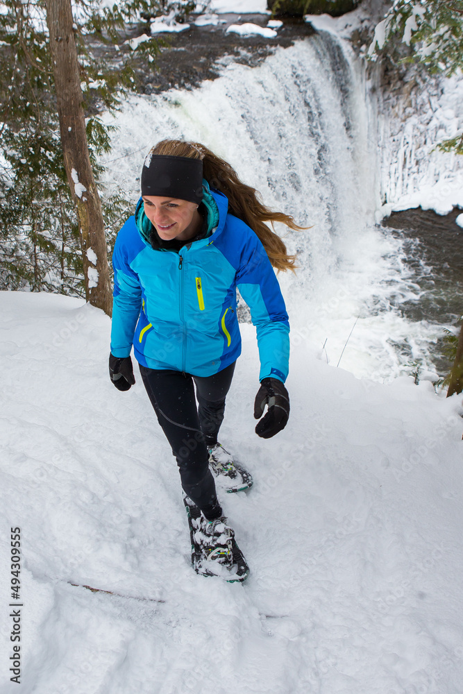 Beautiful woman on snowshoes in the forest in the winter in Canada.