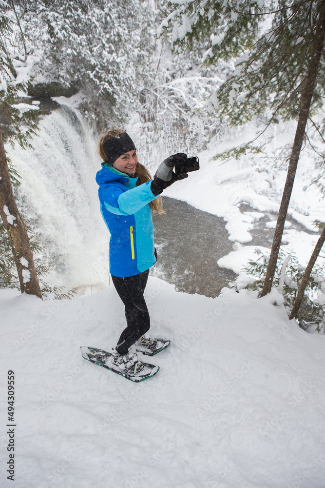 Beautiful woman on snowshoes in the forest in the winter in Canada.