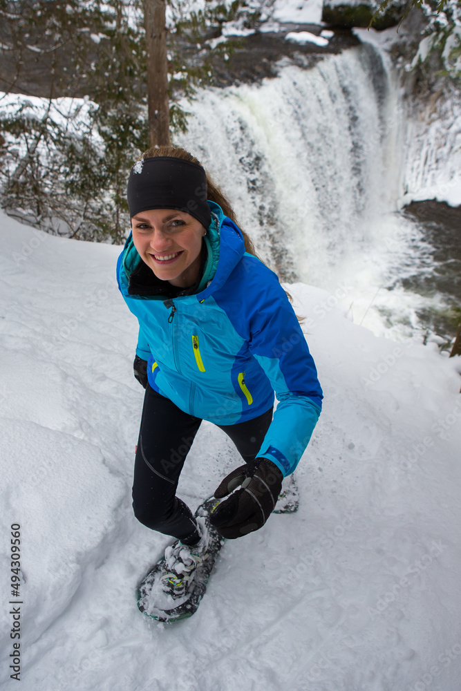 Beautiful woman on snowshoes in the forest in the winter in Canada.