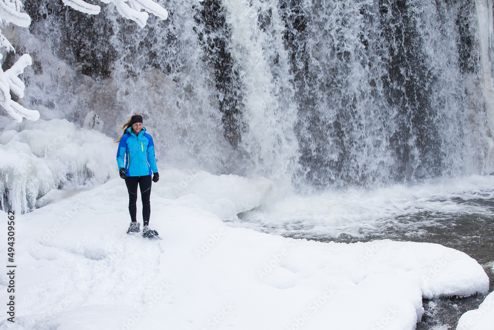 Beautiful woman on snowshoes in the forest in the winter in Canada.