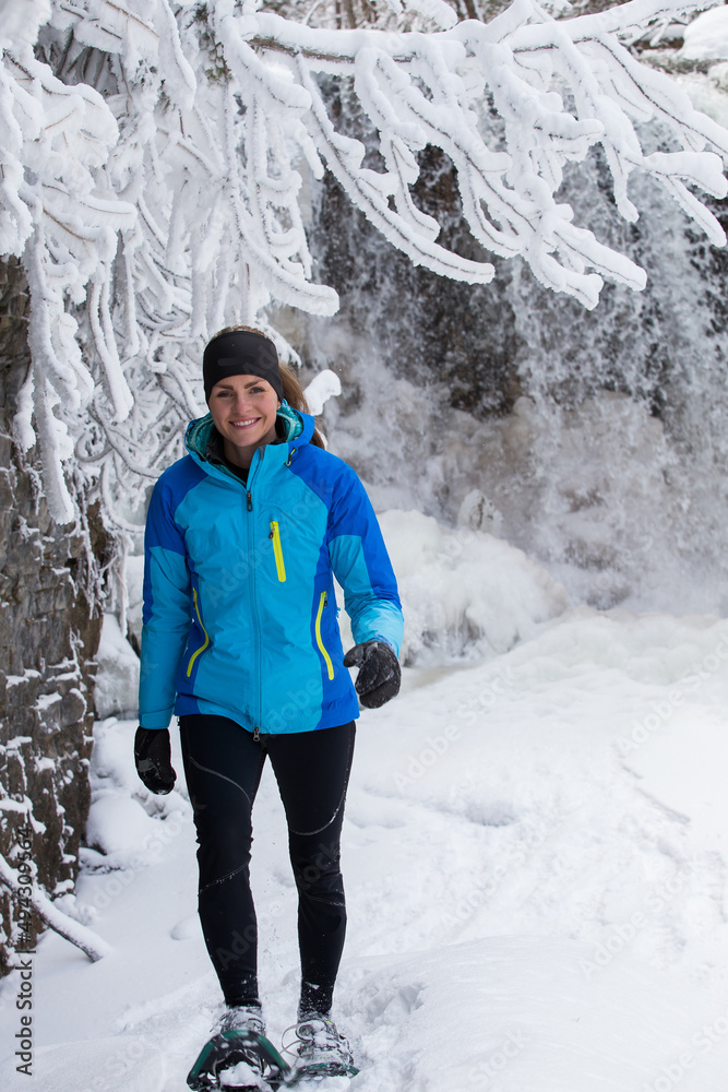 Beautiful woman on snowshoes in the forest in the winter in Canada.