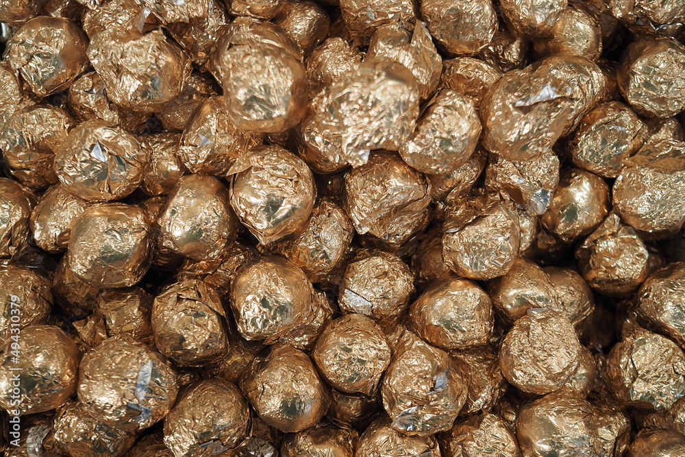 Chocolate sweets. Sweets in golden foil. Full frame background. Chocolate sweets. Sweets in golden foil. Full frame background.