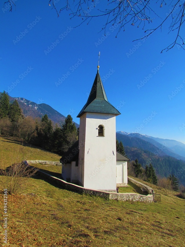 Church at St. Lovrenc in mountains, Gorenjska, Slovenia surrounded by a low stone wall