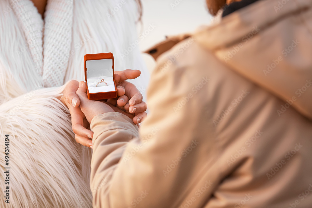 Young couple with engagement ring in box outdoors, closeup Young couple with engagement ring in box outdoors, closeup