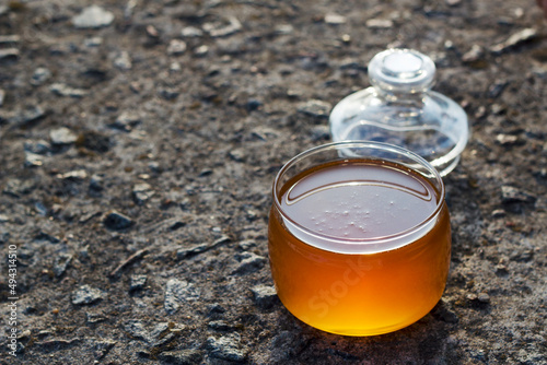 fresh honey in opened jar on the stone background with copy space