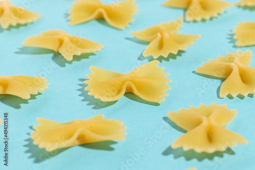 Uncooked italian farfalle pasta on a blue background. Close up.
