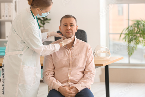 Doctor examining man's neck...