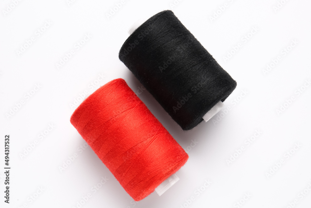 Different thread spools on white background