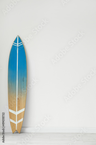 Blue surfboard near light wall in room