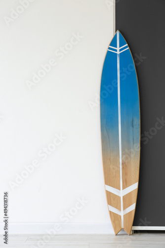 Blue surfboard near wall in room