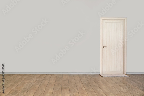 View of light wall with door and mat in big empty room