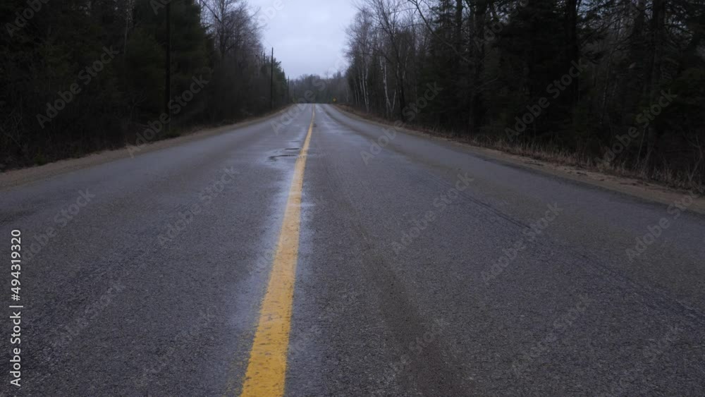 Bleak rural road with light snow or sleet falling. Ontario highway, Canada. Bleak rural road with light snow or sleet falling. Ontario highway, Canada.