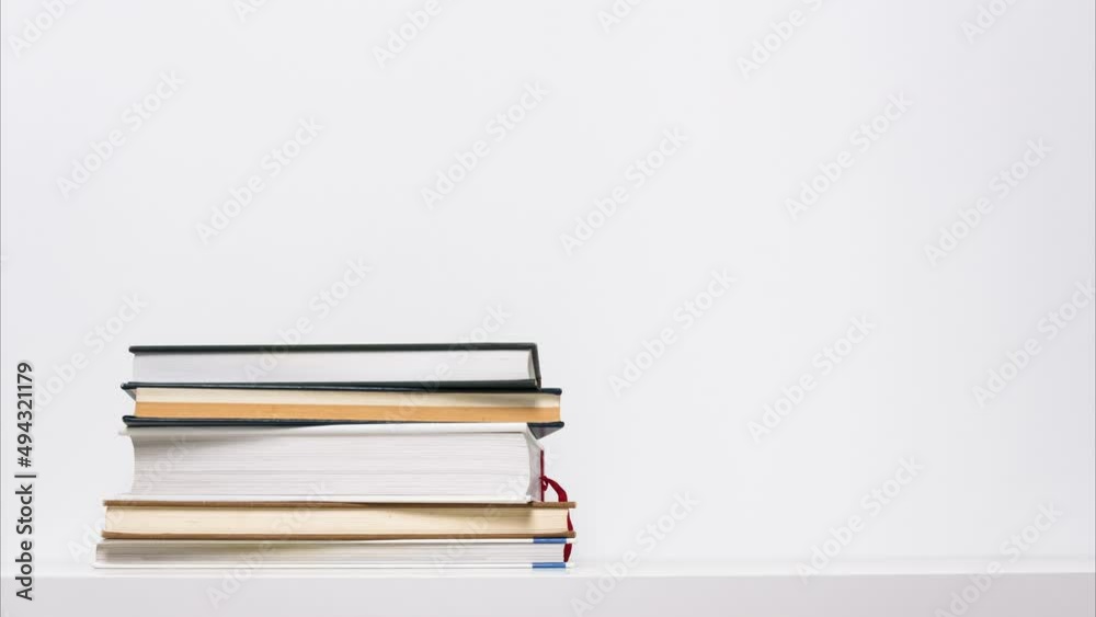 Stop motion animation of growing and shrinking stack of books isolated on white background. Educational or learning concept.
