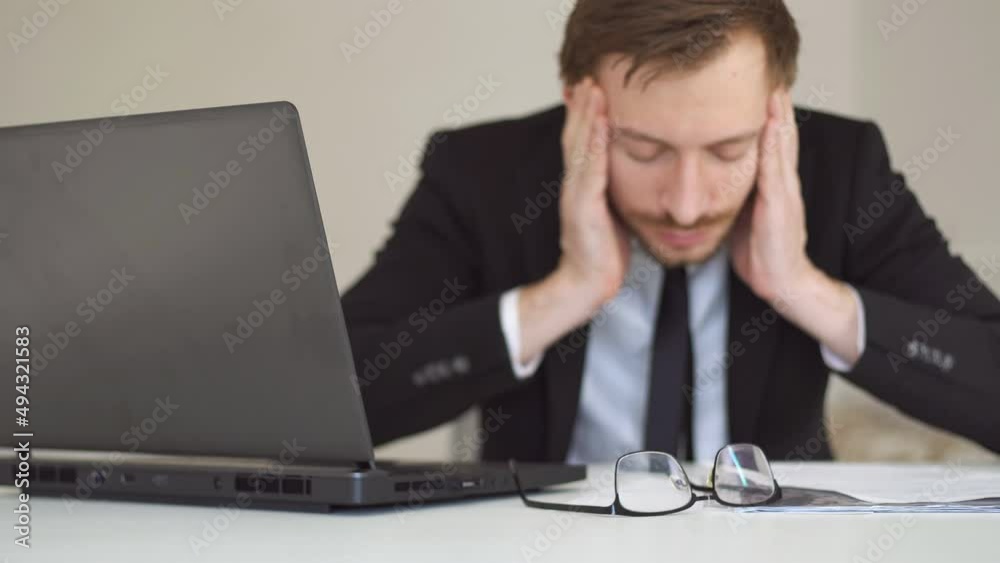 Fatigue businessman sits in front of laptop, feels headache and lack of energy. Bankruptcy and crisis in business. Overworked at job. Fatigue businessman sits in front of laptop, feels headache and lack of energy. Bankruptcy and crisis in business. Overworked at job.