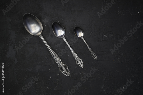Overhead shot of silverware on black table with copy space. © bt1976