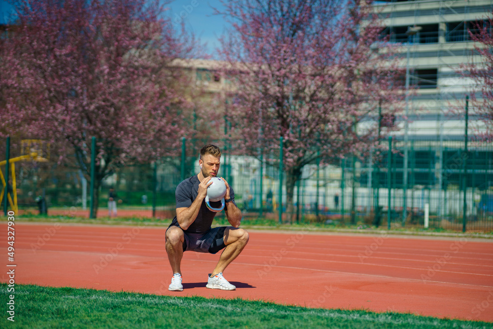 Young muscular man doing exercises with kettlebell outdoor. Weightlifting workout. Sports, fitness concept. Young muscular man doing exercises with kettlebell outdoor. Weightlifting workout. Sports, fitness concept.