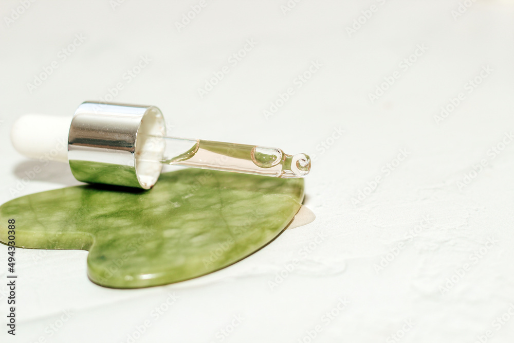 massage stone jade gouache scraper and facial roller with cosmetic cream. massage stone jade gouache scraper and facial roller with cosmetic cream.