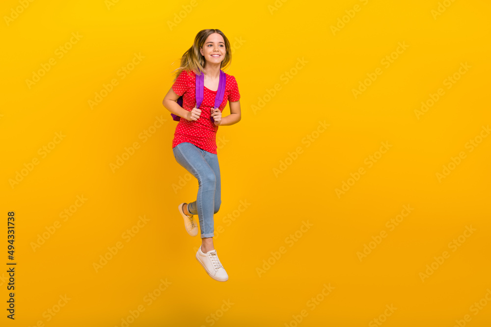 Full size photo of young pretty girl jump bag lesson look empty space isolated over yellow color background