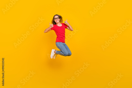 Full body profile side photo of youth lady jump show thumbs-up perfect suggest feedback isolated over yellow color background