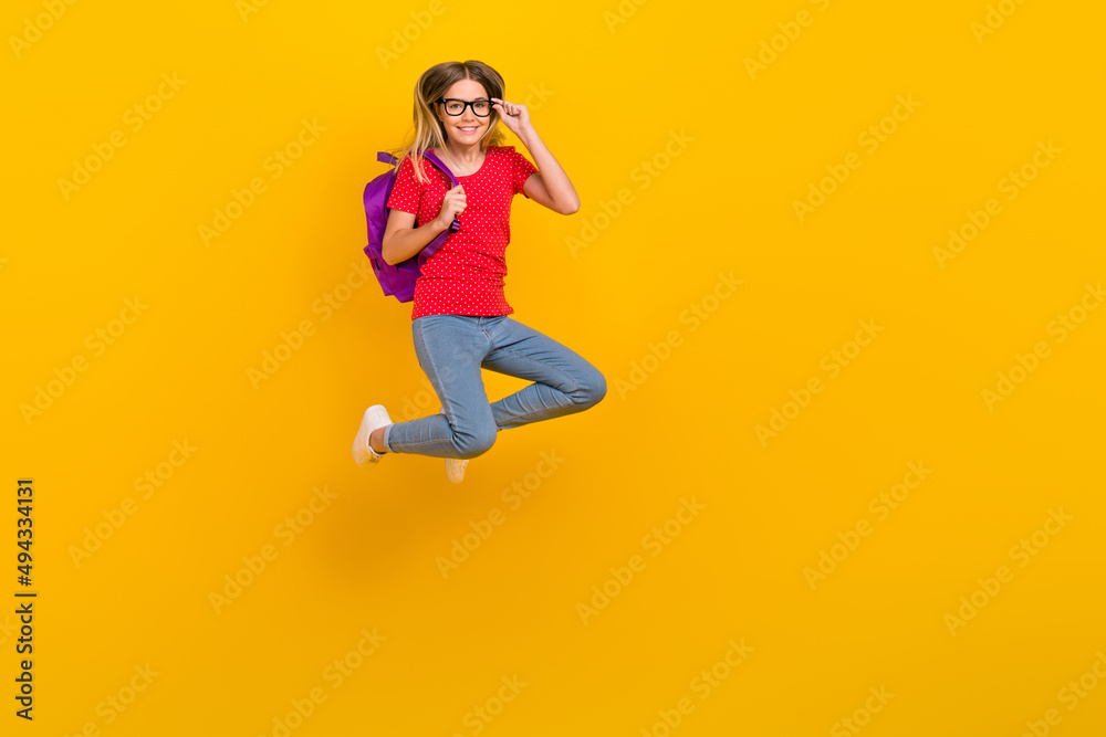 Full size photo of young cheerful lady hold backpack eyewear lesson jumper isolated over yellow color background