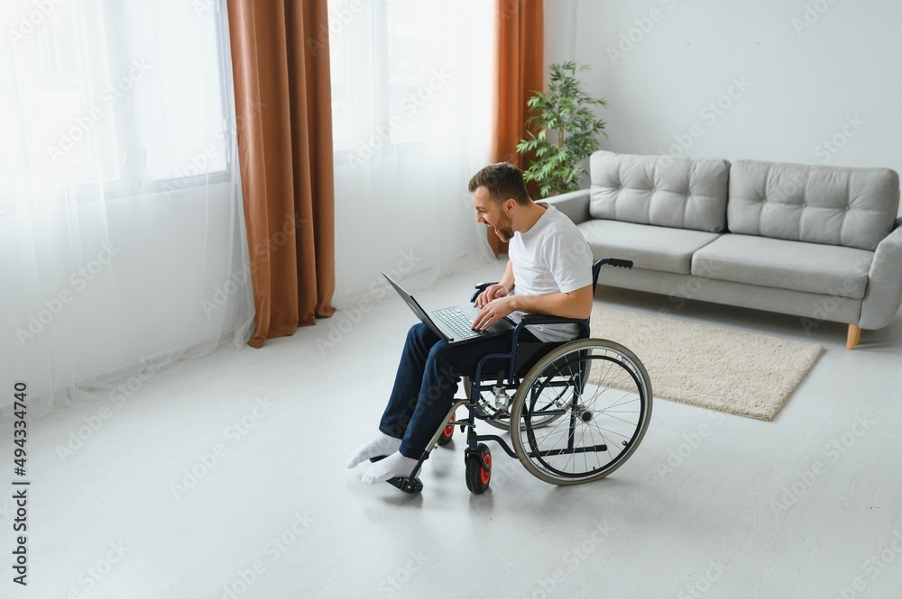Modern young disabled man in wheelchair having video call Modern young disabled man in wheelchair having video call