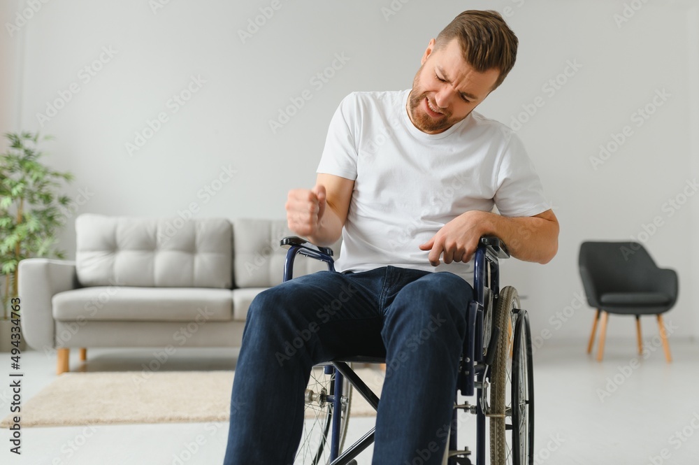 Young sad man in a wheelchair at home. Young sad man in a wheelchair at home.