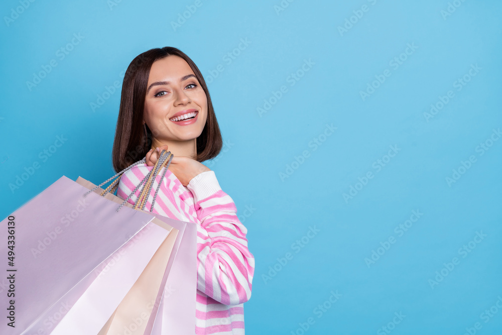 Photo of sweet brunette millennial lady hold bags wear white pullover isolated on blue color background Photo of sweet brunette millennial lady hold bags wear white pullover isolated on blue color background