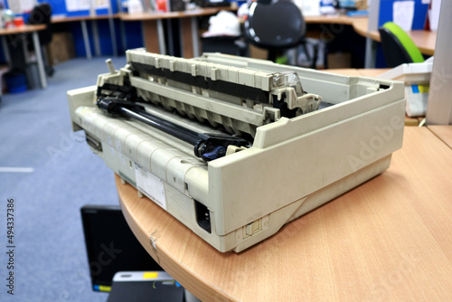 Photo of old and worn dot matrix printer on office desk