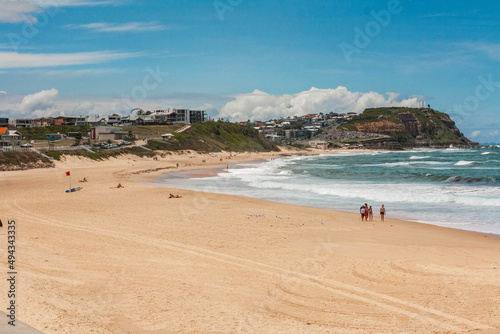 Scenic view of sandy beach and blue wavy ocean on a sunny day in Newcastle, Merewether photo