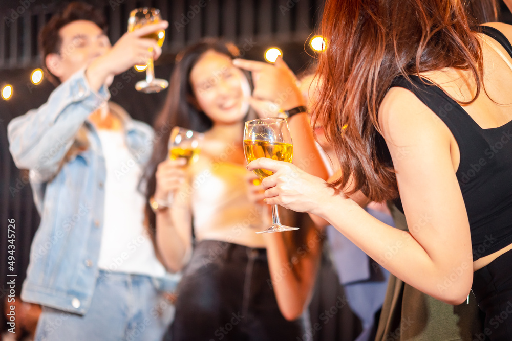 Group Asian girl gang and boyfriends  holding glasses with champagne and cheering with them while having party alcohol. night lifestyle concept.