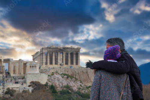 couple in love looks embracing the Acropolis of Athens, Greece